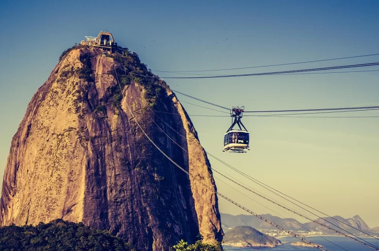 Família feliz no bondinho do Pão de Açúcar, um dos passeios em nossos roteiros com crianças pelo Brasil.