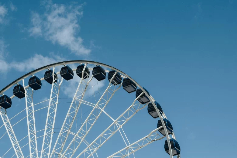 Família com crianças na roda gigante de Balneário Camboriú, com a Praia Central ao fundo.